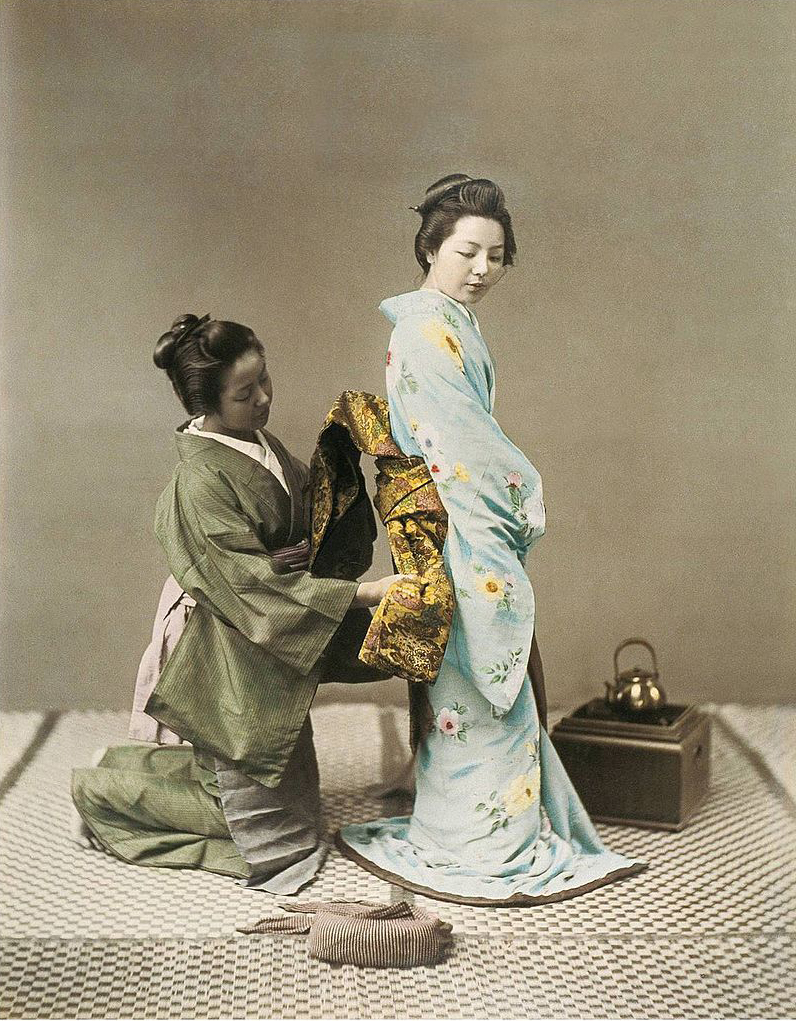 Japanese woman tying an Obi of a geisha in the 1890s.